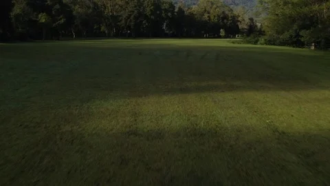 Drone flying over green fields and trees, high mountain and sky 스톡 동영상 247443192