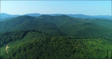 Drone flying over green mountain scape with sun flare in summer day. Stock Footage 127242235