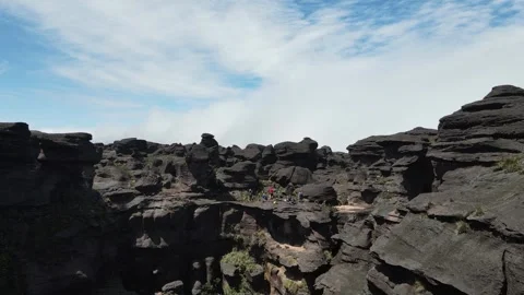 Drone flying over group of hikers standing on Tepui Roraima flat-topped mountain Video stock 242010098