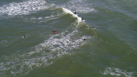 Drone flying over a group of surfers out at sea Stock Footage 305564122
