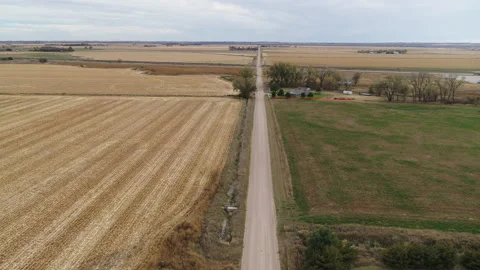 Drone Flying Over Harvested Fields Following Dirt Road Toward Intersection Stock Footage 229185647