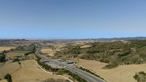 Drone flying over highway in dry spanish desert with vegetation and mountains in 스톡 동영상 119348530