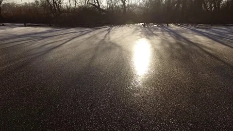 Drone flying over ice and tree's with reflection of sun Video stock 76697216