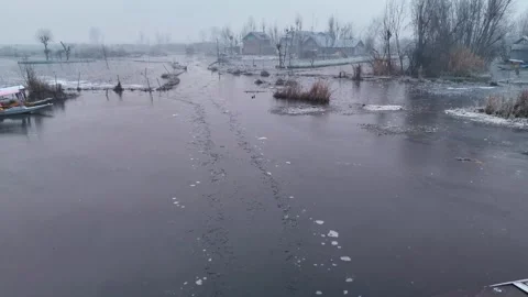 Drone flying over the icy interiors of Dal Lake wrapped in morning mist and Stock Footage 311020552