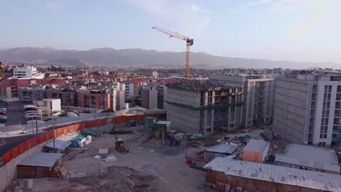Drone flying over an incomplete construction where you can see the crane, 스톡 동영상 143066053