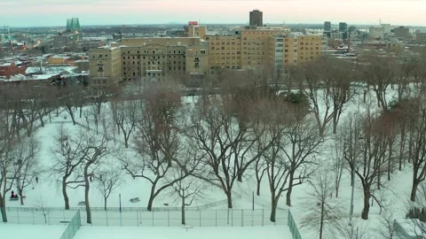 Drone flying over lake in park lafointaine montreal winter tennis courts n main Stock Footage 329003011