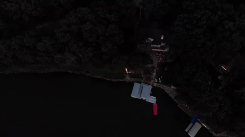 Drone flying over large exploding mortar fireworks being shot over a lake Stock Footage 112079370