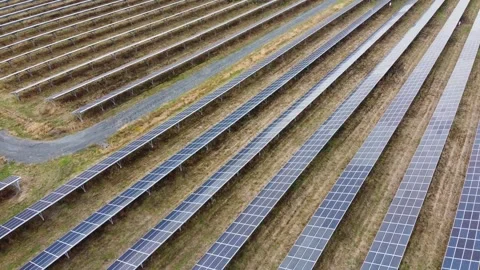 Drone flying over large field of solar panels on sunny day in countryside Stock Footage 280009926