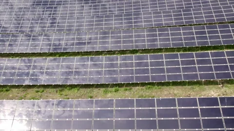 Drone flying over a large solar farm with clouds reflecting Video stock 343831738