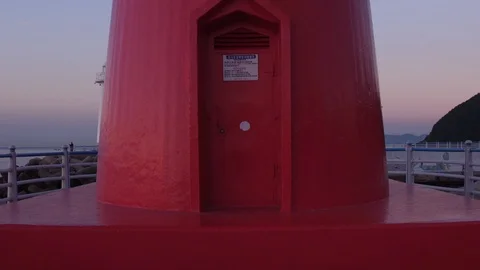Drone flying over a lighthouse at Cheongsapo port in Busan,  aerial view Stock Footage 101001732