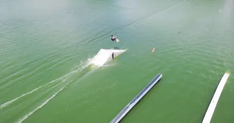 Drone Flying over Man doing Jump Trick and Wakeboarding Cable. Aerial View Vídeo Stock 88976590