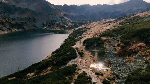 Drone Flying Over Mountain Pond with Sun Reflecting on Small Puddle Stock Footage 165243181