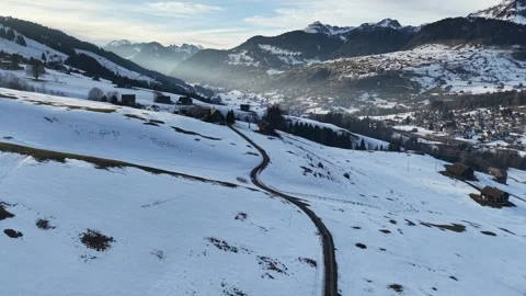 Drone Flying Over Mountain Road With Village at Sunset 스톡 동영상 329557790