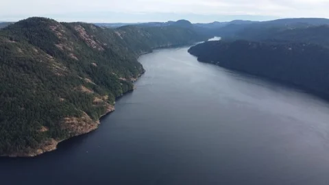 Drone flying over mountains with large river on vancouver island on overcast day 스톡 동영상 280012775