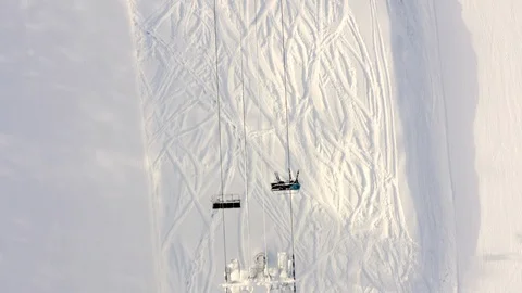 Drone flying over moving ski elevator on snowy slope in mountain resort Stock Footage 124882490