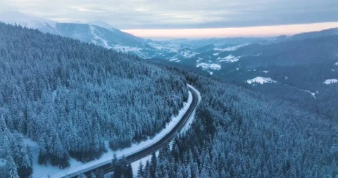 Drone flying over narrow winding road. Middle of the snow-covered white mountain Stock Footage 205096475