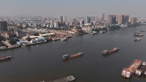 A drone flying over a navigable river on which we see many cargo ships. Video stock 118213660