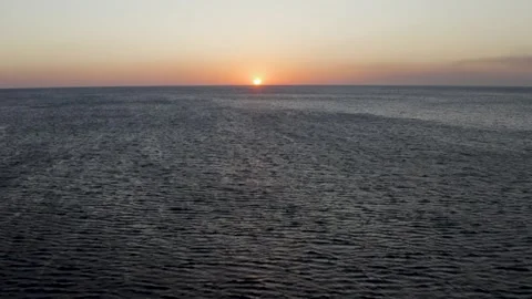 Drone Flying Over the Ocean and Toward Sunset Stock Footage 218389577