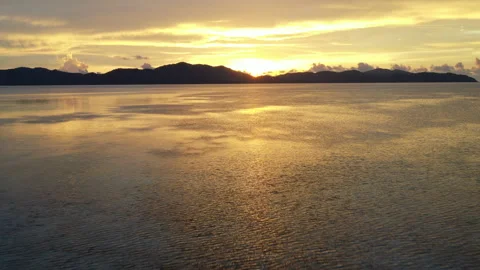 Drone flying over the ocean in a beautiful orange sunset Video stock 231756654