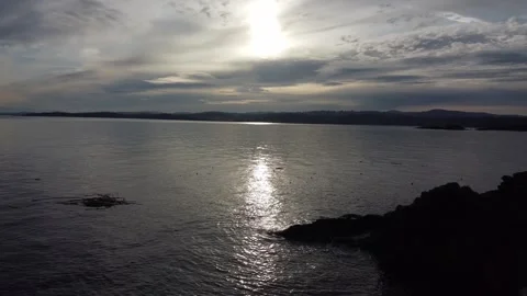 Drone flying over ocean waves on rocks with a sunset and moving clouds Stock Footage 279896721