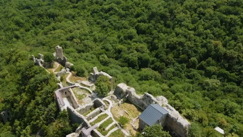 Drone flying over an old georgian ruins on a hill with forest in the background Video stock 229835574