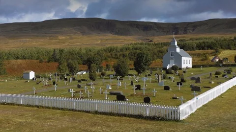 A drone is flying over an old Icelandic typical church Stock Footage 116126610