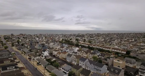 Drone flying over overcast ocean town Video stock 111400071