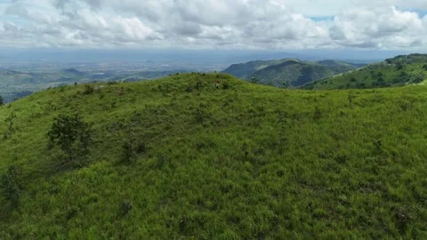 Drone flying over Pa Sol grasslands with hikers crossing rolling hills 動画素材 337046483