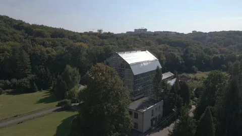 Drone flying over the park with a huge greenhouse in the center Stock Footage 163824868