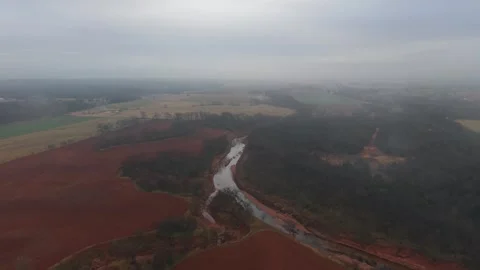 Drone Flying Over Red Dirt Farmland and Winding Creek in Morning Stock Footage 330195284