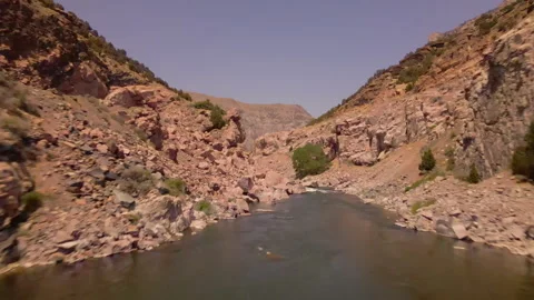 Drone flying over river in mountain valley like top gun jet Stock Footage 247560519