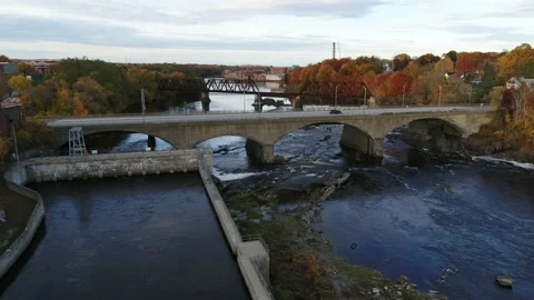 Drone Flying Over River Past Busy Bridge Near Rural Factory Town Stock Footage 229175602