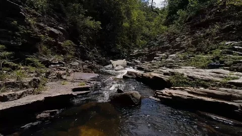 Drone flying over a river with several rocks 動画素材 97838862