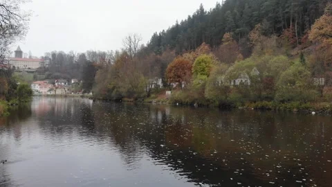 Drone flying over a river in a small historical Czech town in autumn Stock Footage 257875609