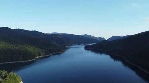 Drone flying over a river snaking through a forest covered mountain valley Stock Footage 162456659