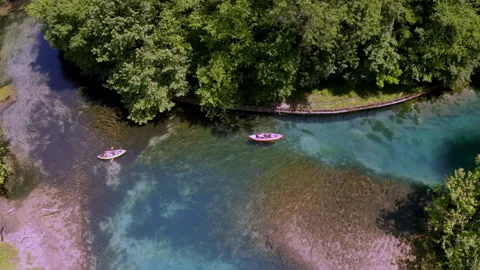 Drone flying over a river with two canoes near to a forest Video stock 263887481