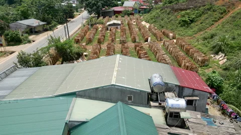 Drone flying over the road and outdoor wood warehouse in a rural area in vietnam Stock Footage 303844455