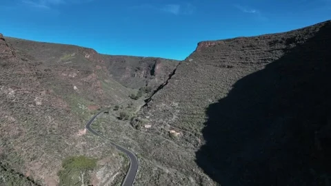 Drone Flying Over Road in Dramatic Green Mountain Valley Under Blue Sky Stock Footage 309949176