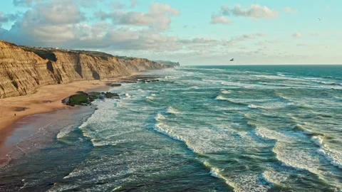 Drone is flying  over rolling ocean waves to the rocky shore.  Stock Footage 197558362