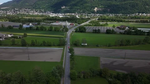 Drone flying over rural road and farmland with hilltop castle in background 動画素材 334570184