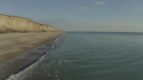 A drone flying over a sandy seashore on a cloudy Видео 241316032