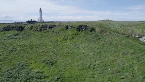 Drone flying over a scenic Isle of Arran Lighthouse  with blue skies and cl.. Stock Footage 278009862