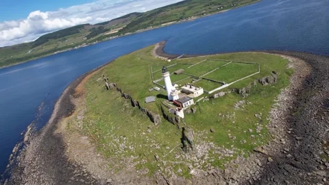 Drone flying over a scenic Isle of Arran Lighthouse  with blue skies and cl.. Stock Footage 278009872