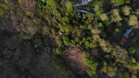 Drone flying over several isolated rural houses at the base of a green valley. Stock Footage 201525731
