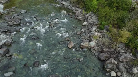 Drone flying over shallow river with large rocks and fast flowing water Stock Footage 280008295