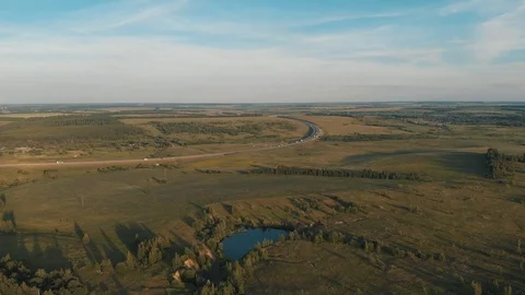 Drone flying over small lake surrounded by sparse vegetation Stock Footage 120166330