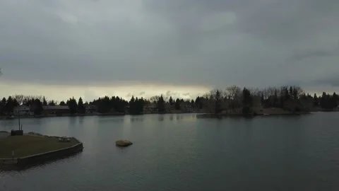 Drone flying over a small lake with beautiful dark sunset clouds Stock Footage 167566798