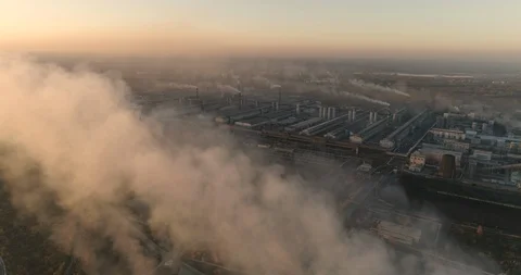 Drone flying over smoking chimneys of a steel factory. Aerial top view of Stock Footage 125413629