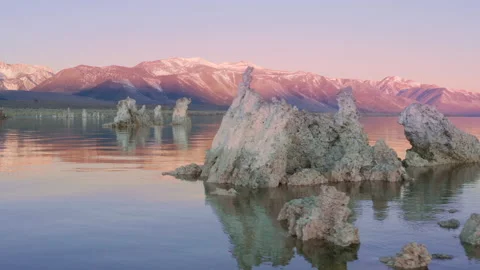 Drone flying over smooth lake surface with scenic rocks. Mountain on background Stock Footage 144650285