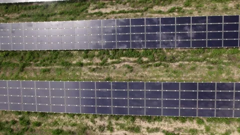 Drone flying over a solar farm with sun and clouds reflecting Stock Footage 343831591